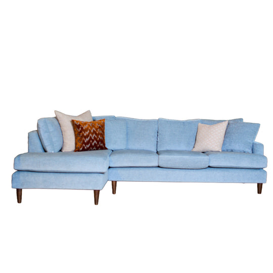 Light blue sectional sofa with decorative pillows on a white background