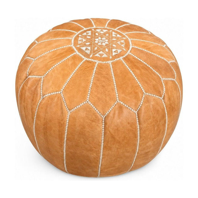 Tan round pouf ottoman with a low cylindrical silhouette.