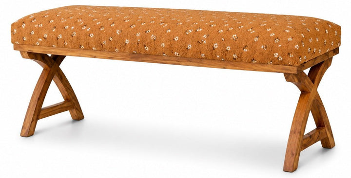 Kalalou upholstered bench with warm patterned fabric and crossed wooden supports on a white studio background.