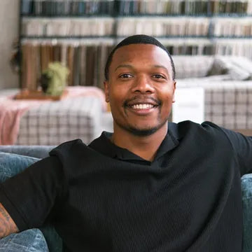 Julius, our store manager, smiling on a showroom sofa