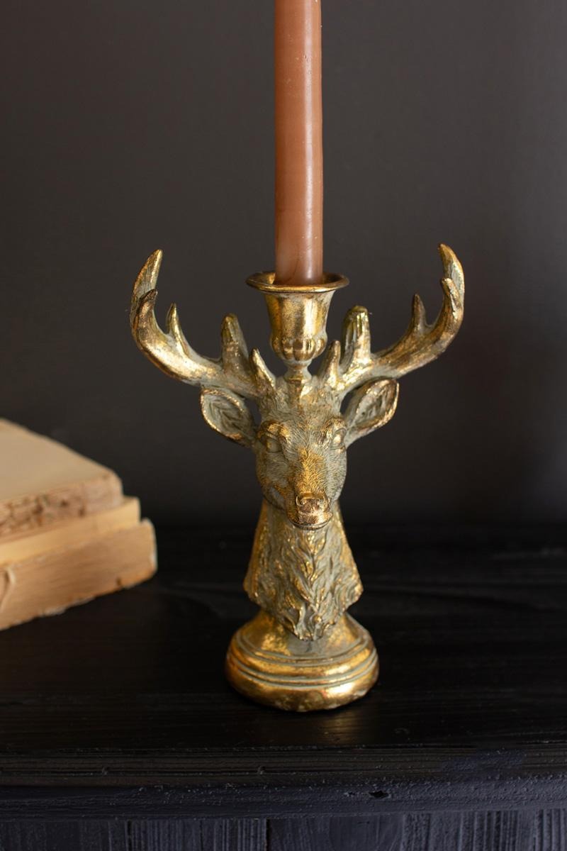 Antique Gold Deer Head Taper Candle Holder styled against a dark wall with a lit taper candle - antiqued gold stag candle holder by Kalalou - Whats New Furniture Portland OR