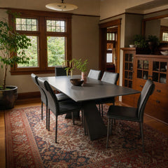 Gray Gunnar dining table with a long tempered glass top and mid-century frame. - detail view 1
