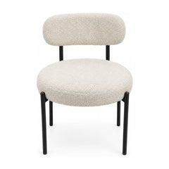Cream boucle dining chairs with a looped texture and compact seat.