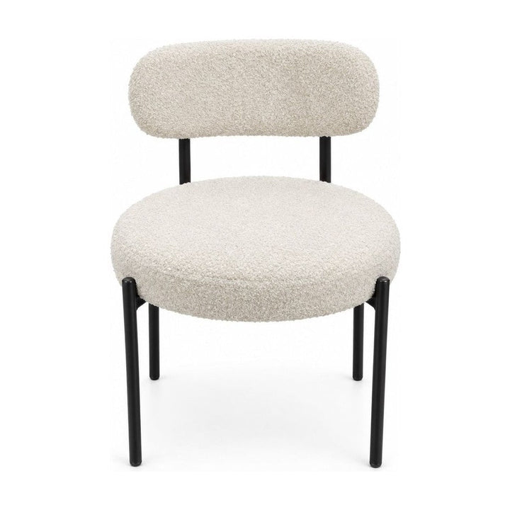 Cream boucle dining chairs with a looped texture and compact seat.