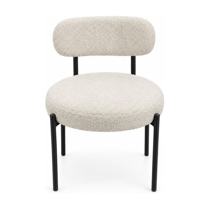 Cream boucle dining chairs with a looped texture and compact seat.