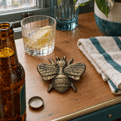 Distressed gold cast iron bee bottle opener styled on a Portland bar cart - Whats New Furniture