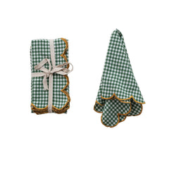 Green check scalloped napkins tied with cotton tape next to a folded napkin