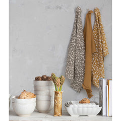 Ruffled cotton tea towels hanging in a styled kitchen