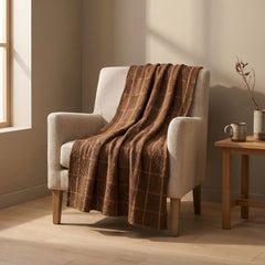 Brown waffle weave cotton throw styled over a cream armchair beside a wood side table in a Portland living room - Whats New Furniture