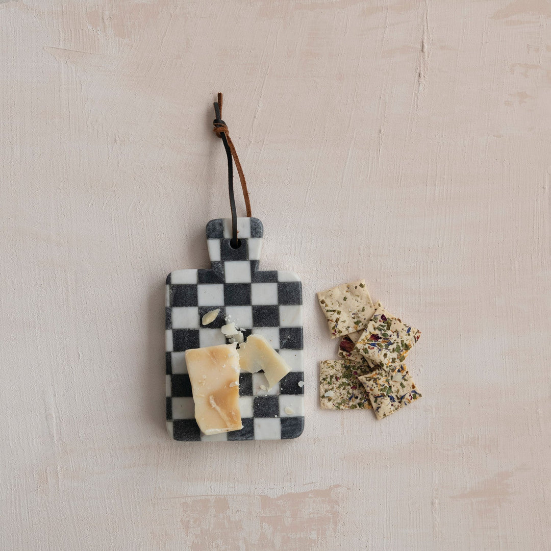 Checkerboard marble board hanging above a cheese spread