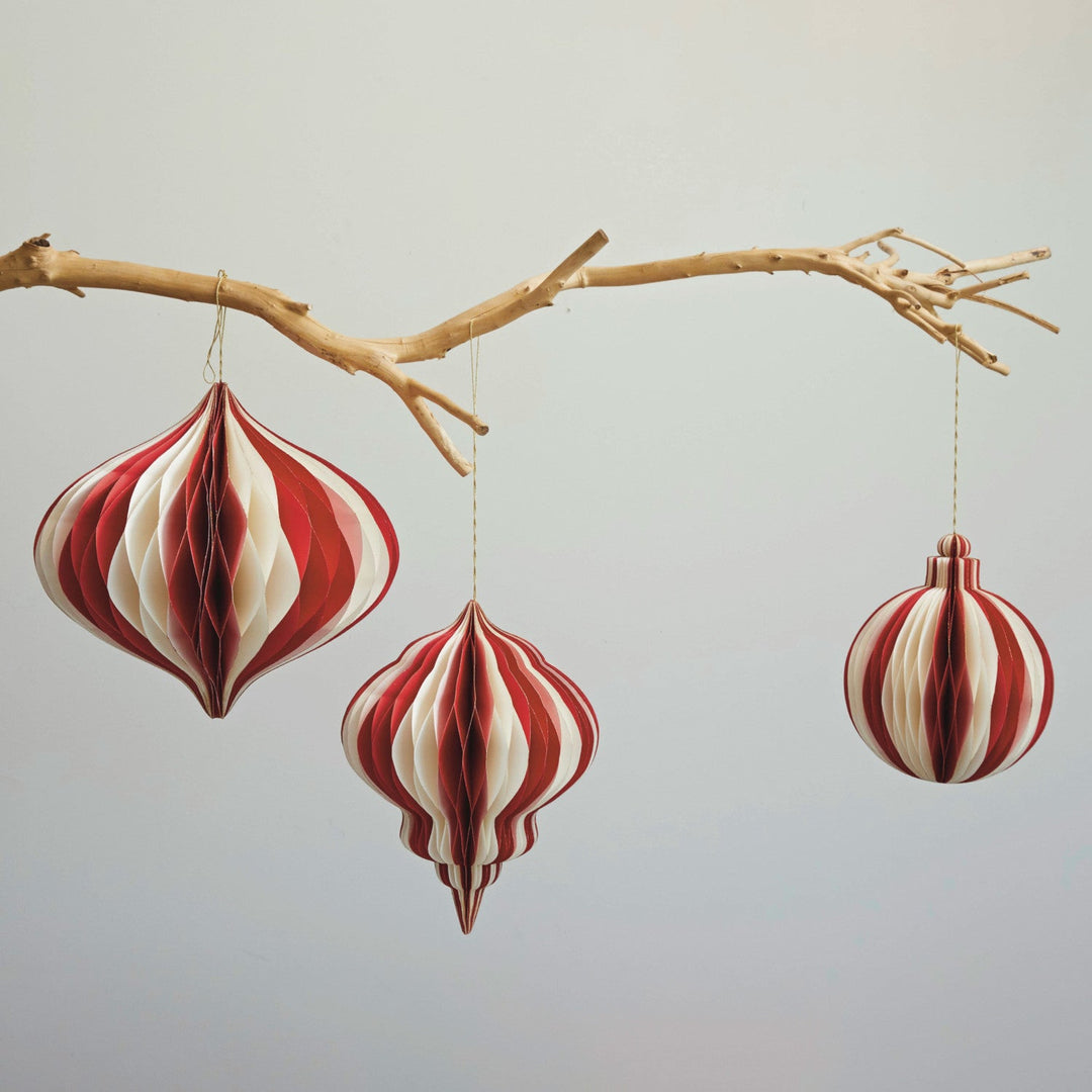 Red and cream honeycomb ornaments styled hanging from a driftwood branch in a Portland holiday display - Whats New Furniture