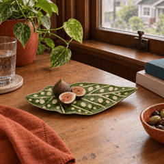 Green stoneware leaf plate styled with fresh figs on a Portland dining table - Whats New Furniture