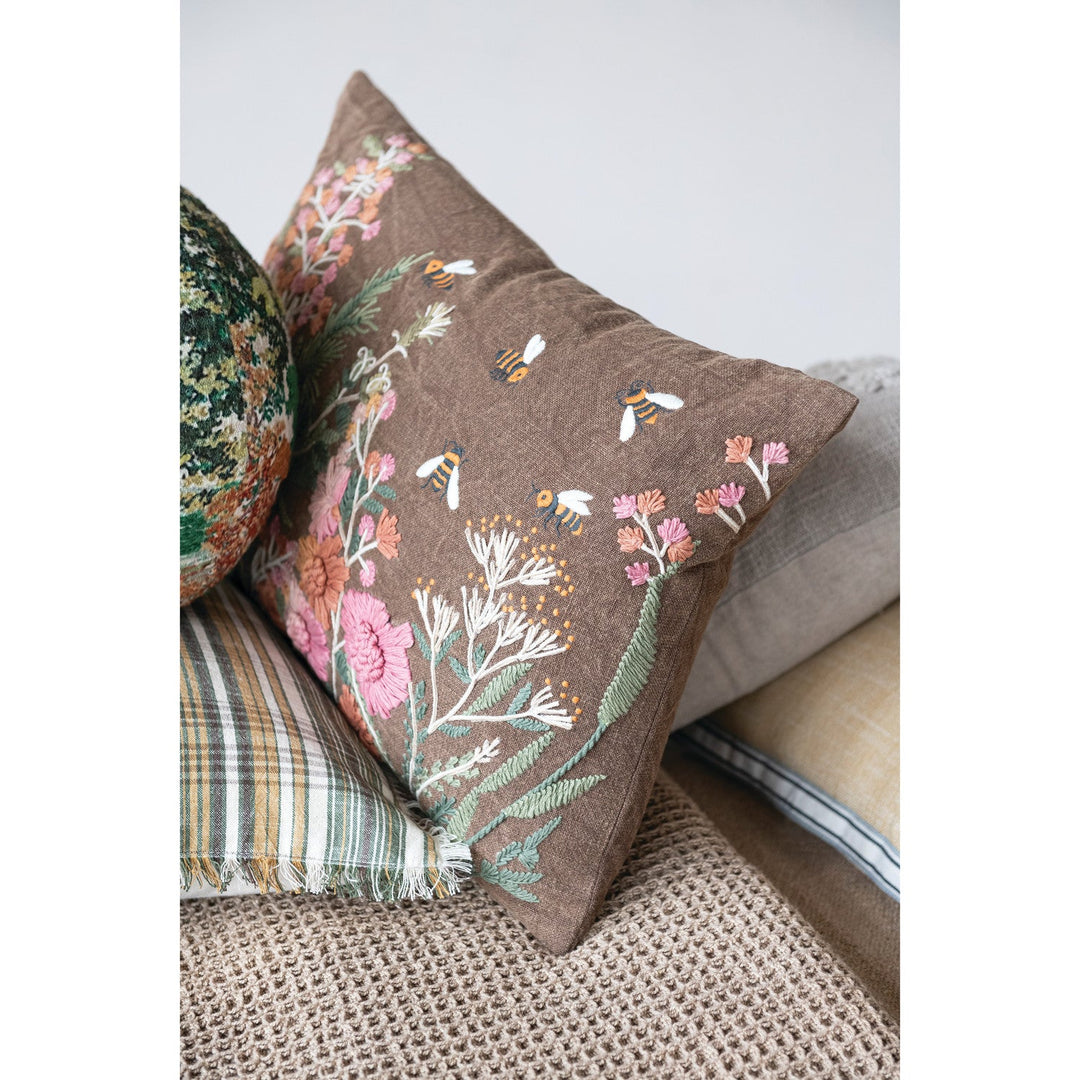 Stonewashed Cotton Slub Lumbar Pillow with Hand-Embroidered Flowers &amp; Bees, 20" x 14" styled on a bench - soft goods by Creative Co-Op - Whats New Furniture Portland OR