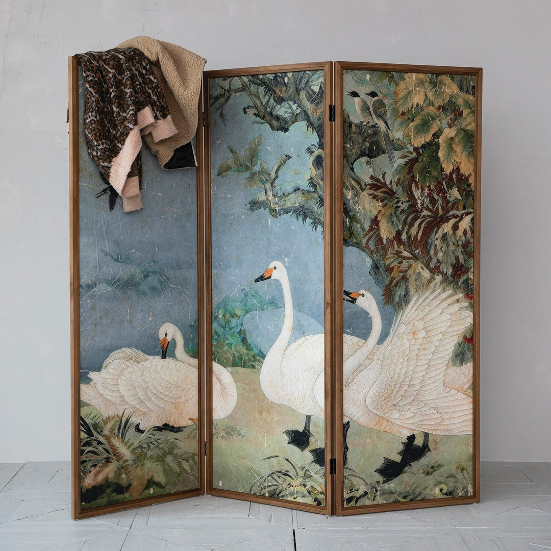 Folding room divider with swan artwork shown at an angle with a coat draped over one panel - Creative Co-Op screen - Whats New Furniture Portland