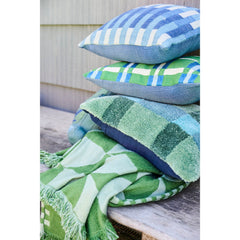Green fan pattern indoor outdoor throw styled on a weathered teak bench with blue and green outdoor pillows on a Portland patio - Whats New Furniture