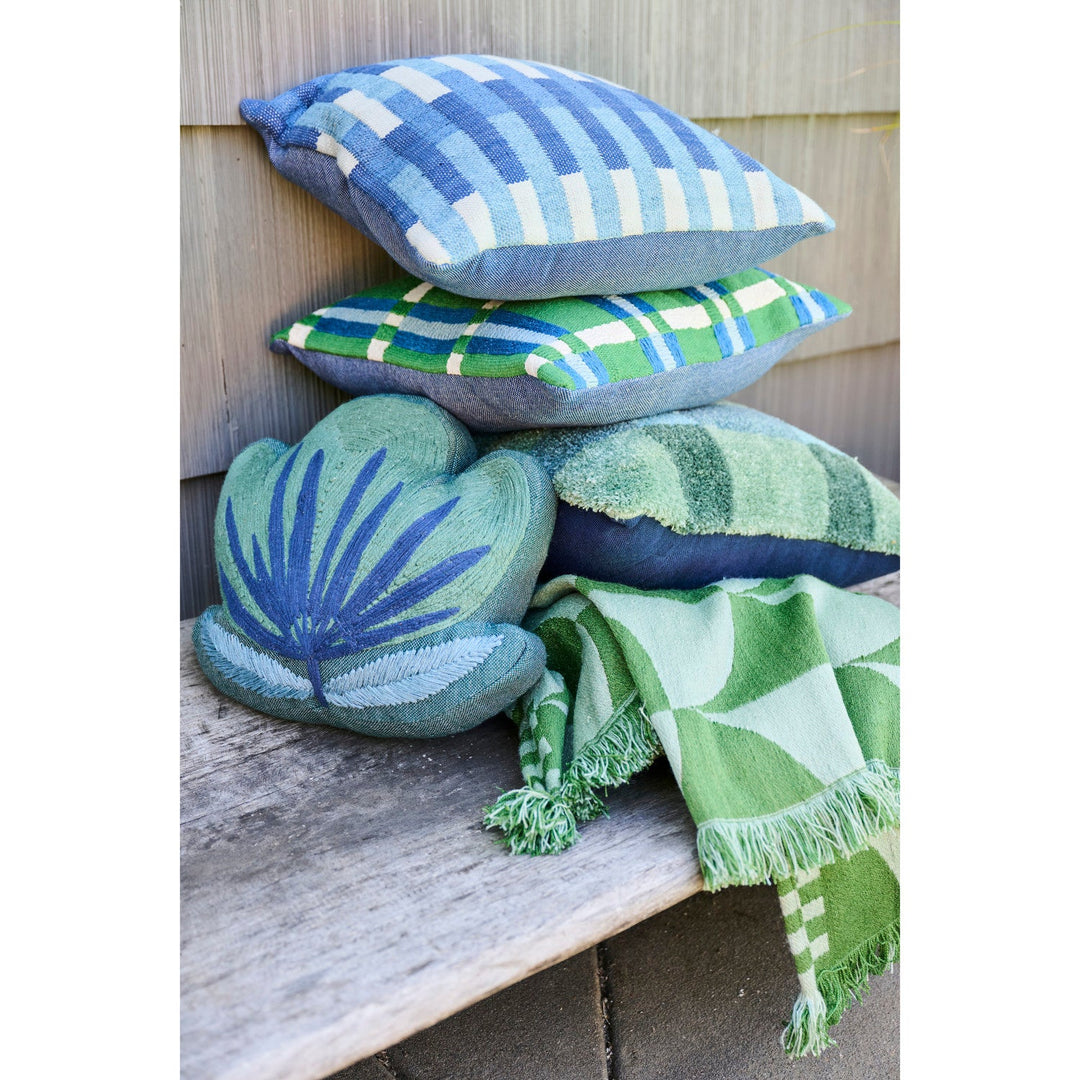 Outdoor throw with fan pattern styled in a stack of patio pillows with a palm leaf pillow on a garden bench - Whats New Furniture Portland OR