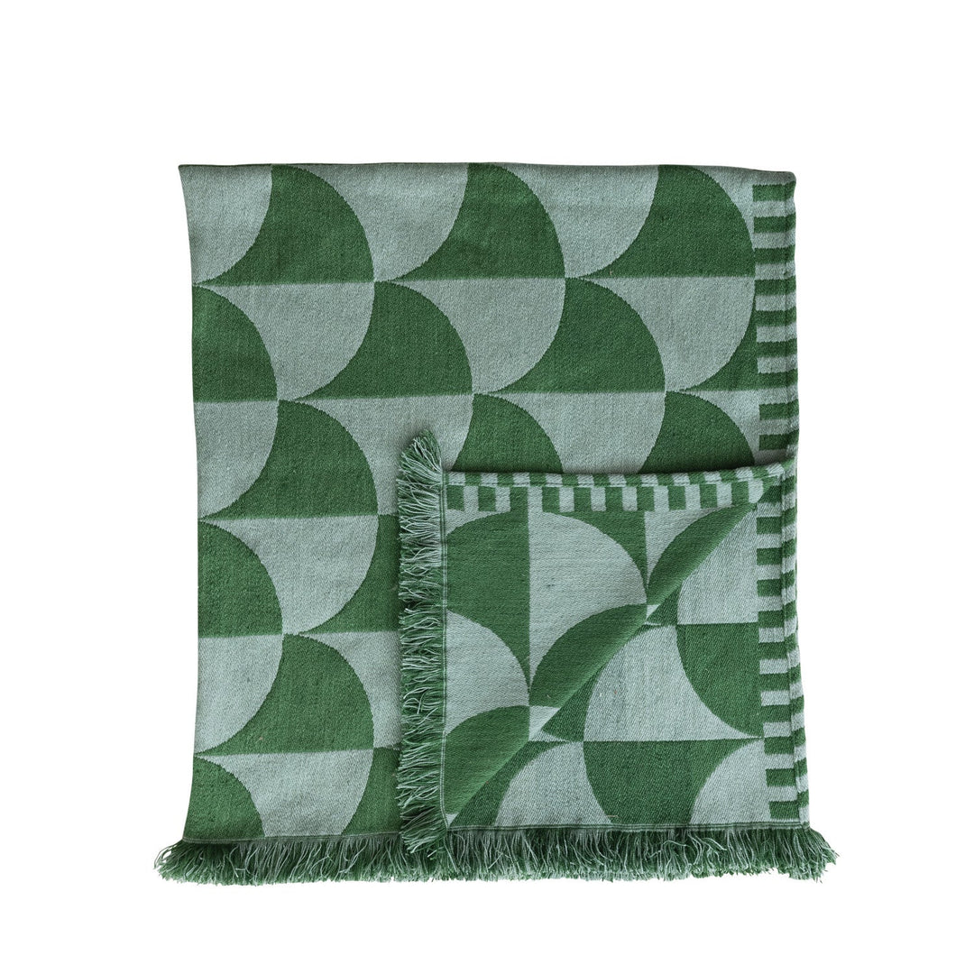 Folded green indoor outdoor throw showing the reversed fan pattern on the back face and fringe - Whats New Furniture Portland