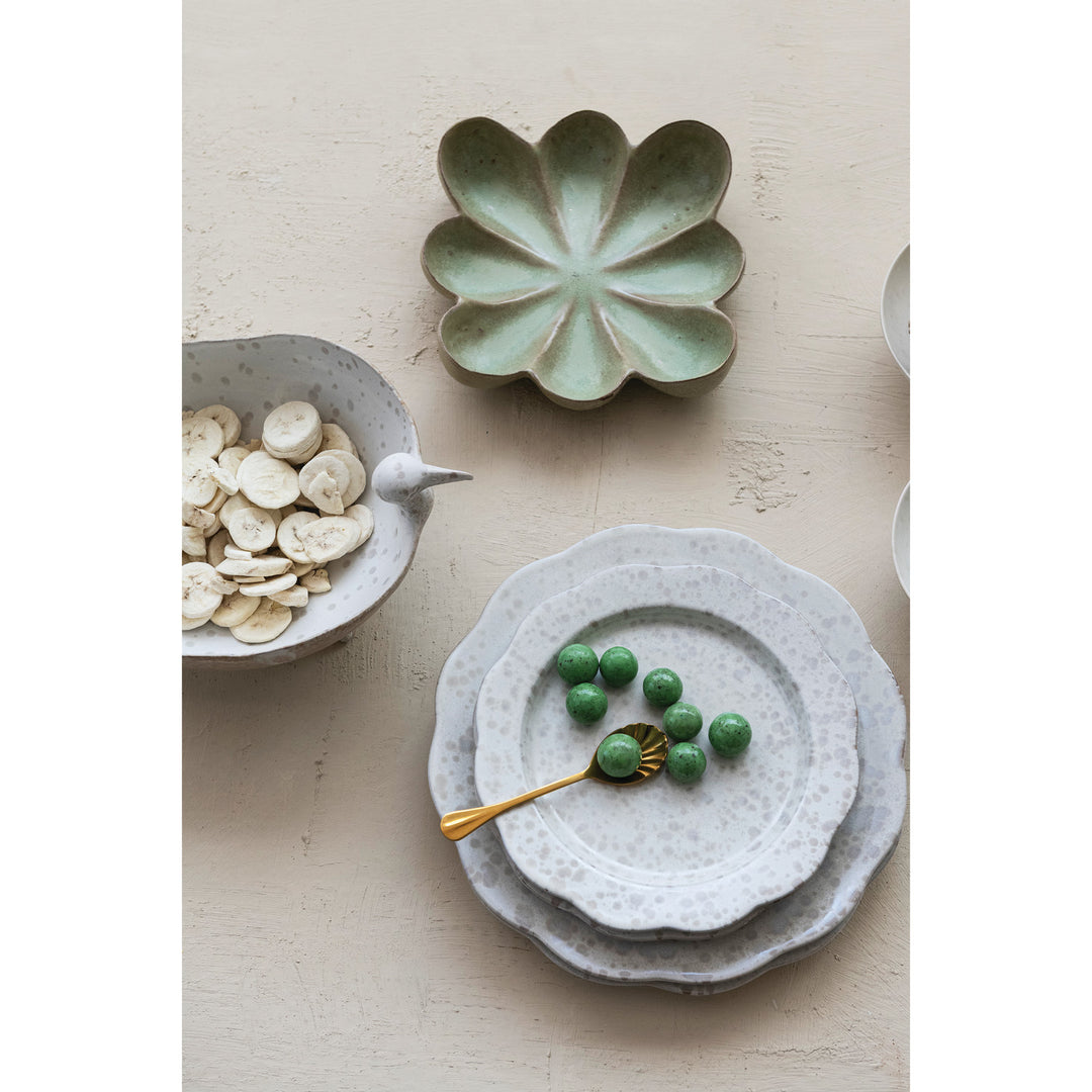 Green flower-shaped stoneware dish styled with speckled dinnerware and olives - Creative Co-Op - What&