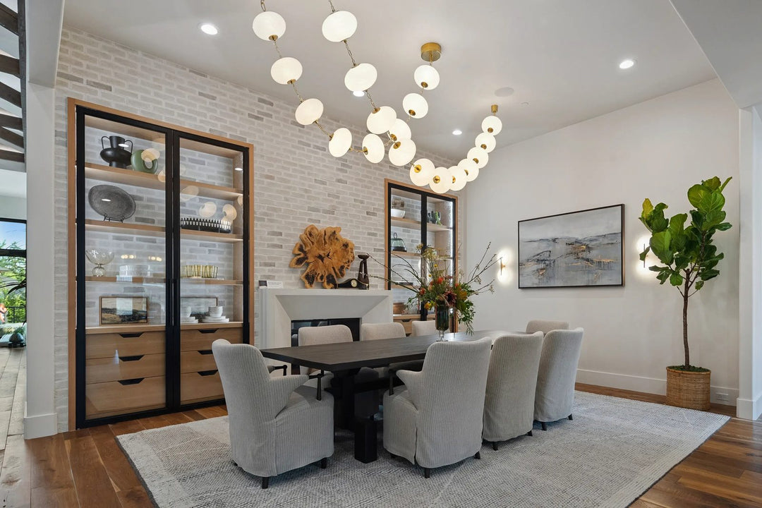 Dining room interior design by Whats New Furniture in Lake Oswego Oregon - modern table with slipcovered chairs bubble chandelier and brick accent wall