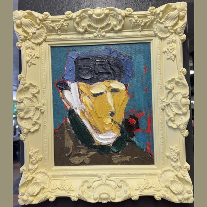 Framed acrylic portrait painting in a carved pale yellow baroque frame, photographed in the What's New Furniture showroom