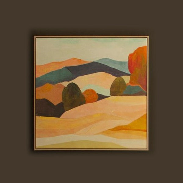 Framed landscape painting of layered hills in a light wood floater frame