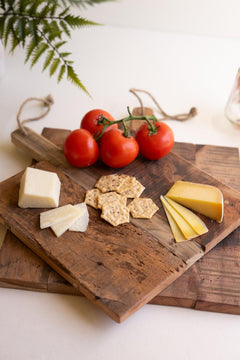 Large recycled wood cheese board styled at an angle with sliced cheese, crackers and vine tomatoes - reclaimed wood decor by Kalalou - Whats New Furniture Portland OR