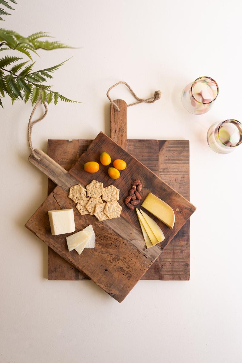 Overhead flat lay of both recycled wood cheese boards layered with cheese, crackers, almonds and kumquats - reclaimed wood decor by Kalalou - Whats New Furniture Portland OR