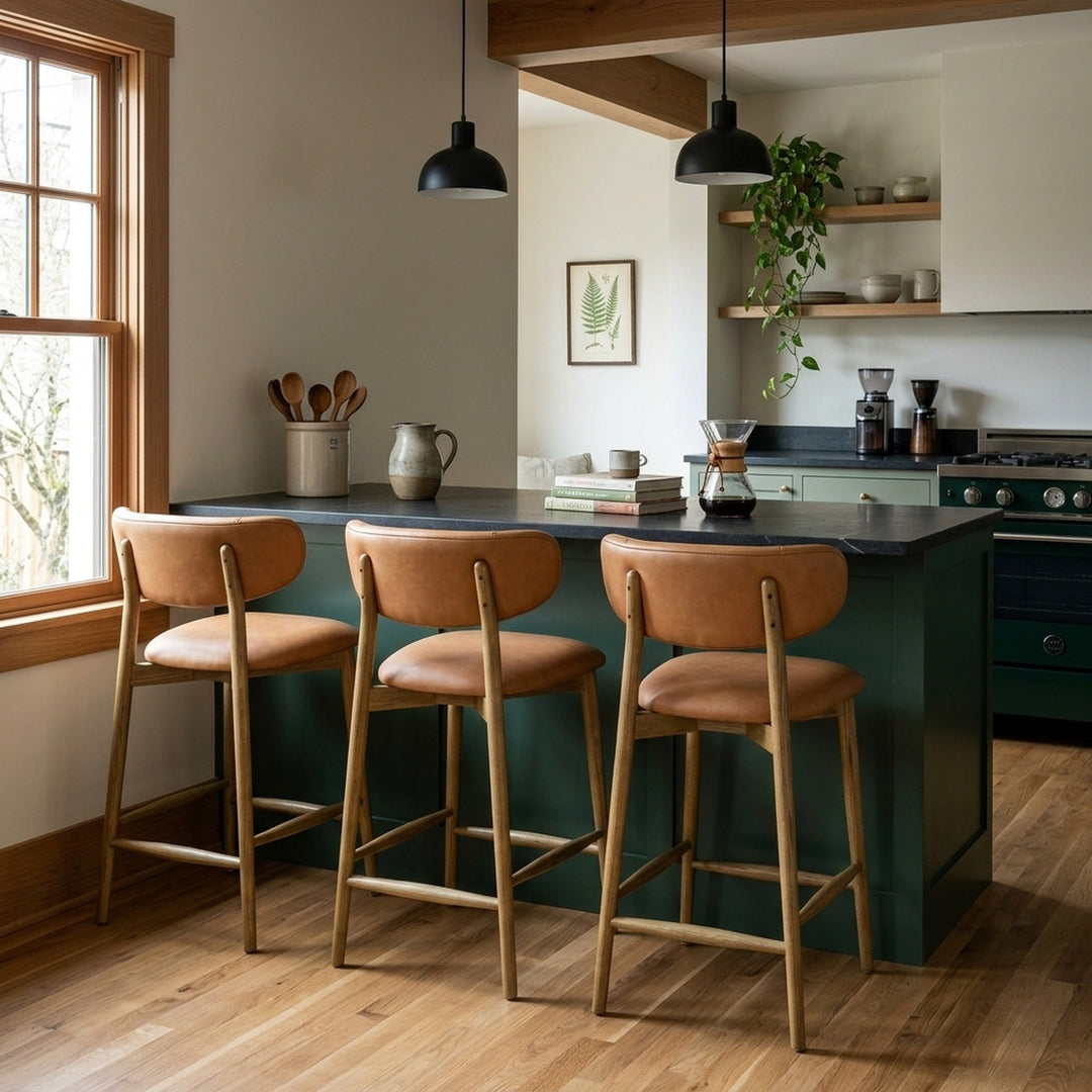 Milo Counter Stool in Tan top-grain leather styled at a kitchen island in a Portland Craftsman kitchen with forest green cabinets and exposed beam — What&