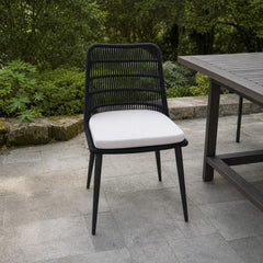 Naples Outdoor Dining Chair on a stone paver patio beside a slatted-wood outdoor dining table - What&