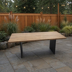 Naples Outdoor Dining Table on a stone paver backyard patio with a warm cedar fence - What&