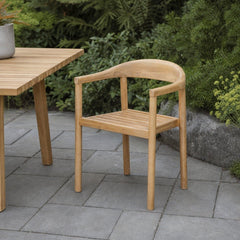 Sonoma Outdoor Dining Chair on a stone paver patio beside a slatted-wood outdoor dining table - What&