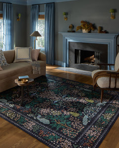 Canopy charcoal rug styled in a blue-toned living room with a fireplace and traditional furniture - Rifle Paper Co. x Loloi - Whats New Furniture