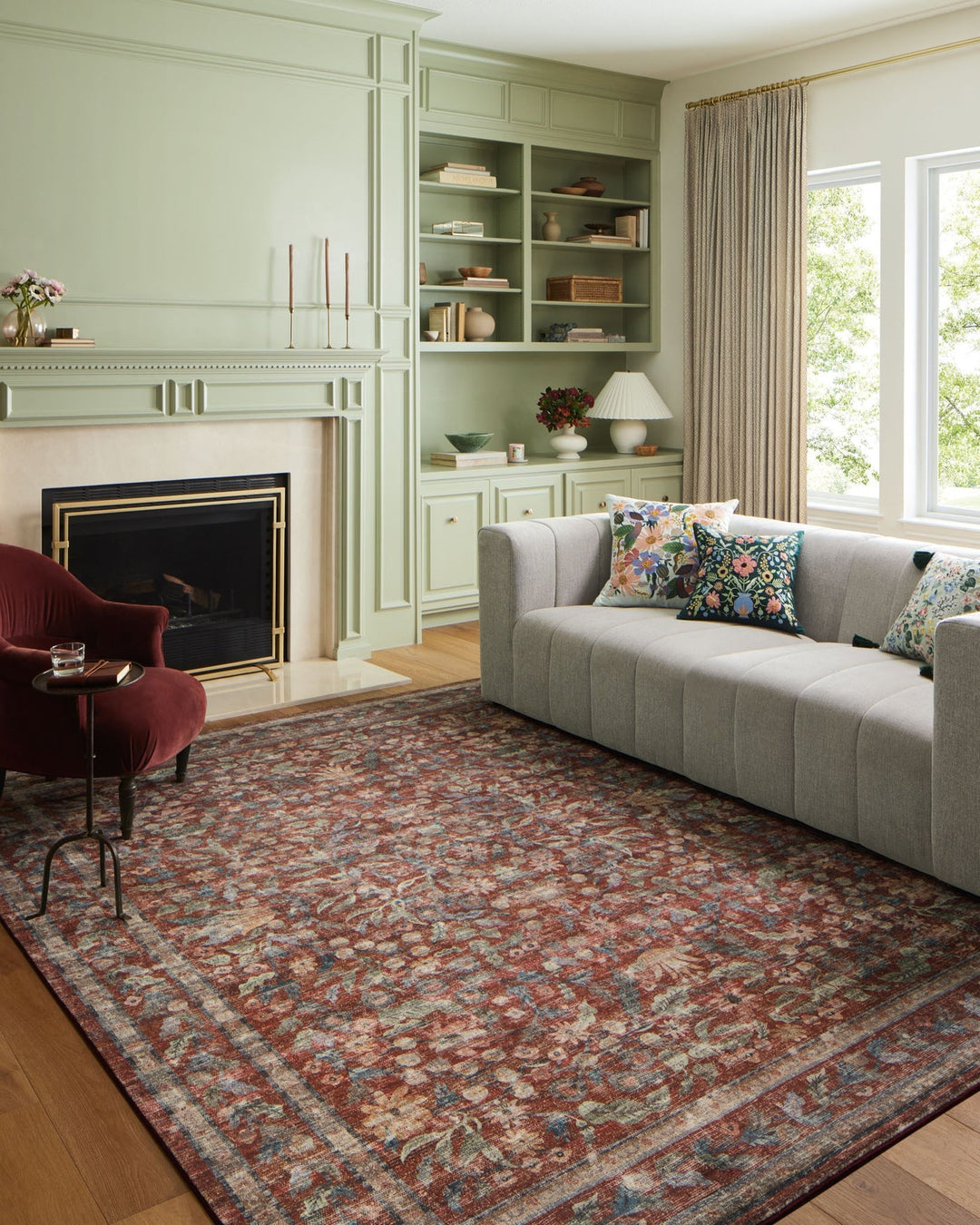 Eve Crimson Courtyard rug styled in a sage-green living room with built-in shelves and a fireplace - Whats New Furniture