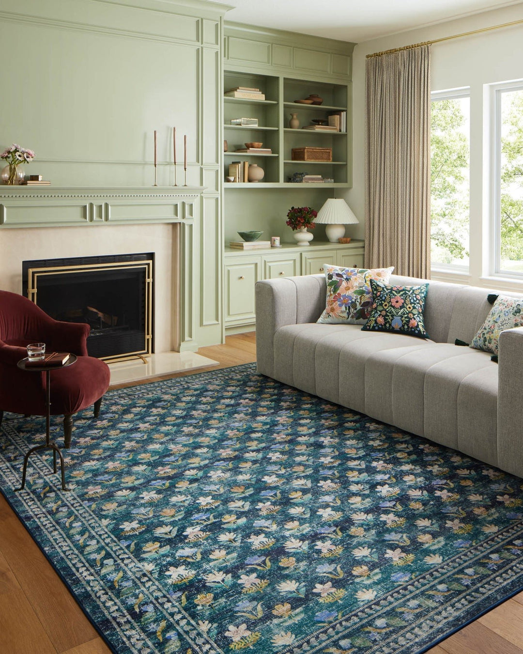 Hadley Emerald Courtyard rug styled in a green living room with a grey sofa and fireplace - Whats New Furniture