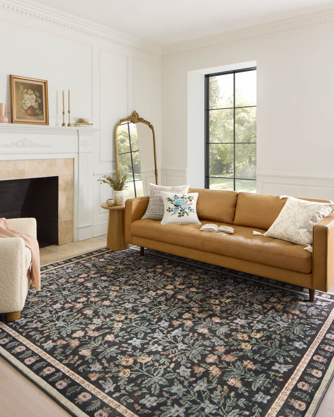 Mughal Garden Black Eden rug styled in a bright living room with a camel leather sofa - Whats New Furniture