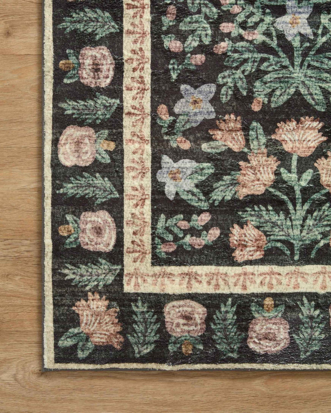 Corner detail of the Eden Mughal Garden Black rug showing the cream floral border - Whats New Furniture Portland OR