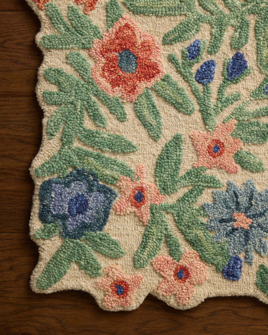 Close-up of the hand-tufted peach and blue blooms on the Edith Ivory Multi accent rug - Whats New Furniture Portland OR