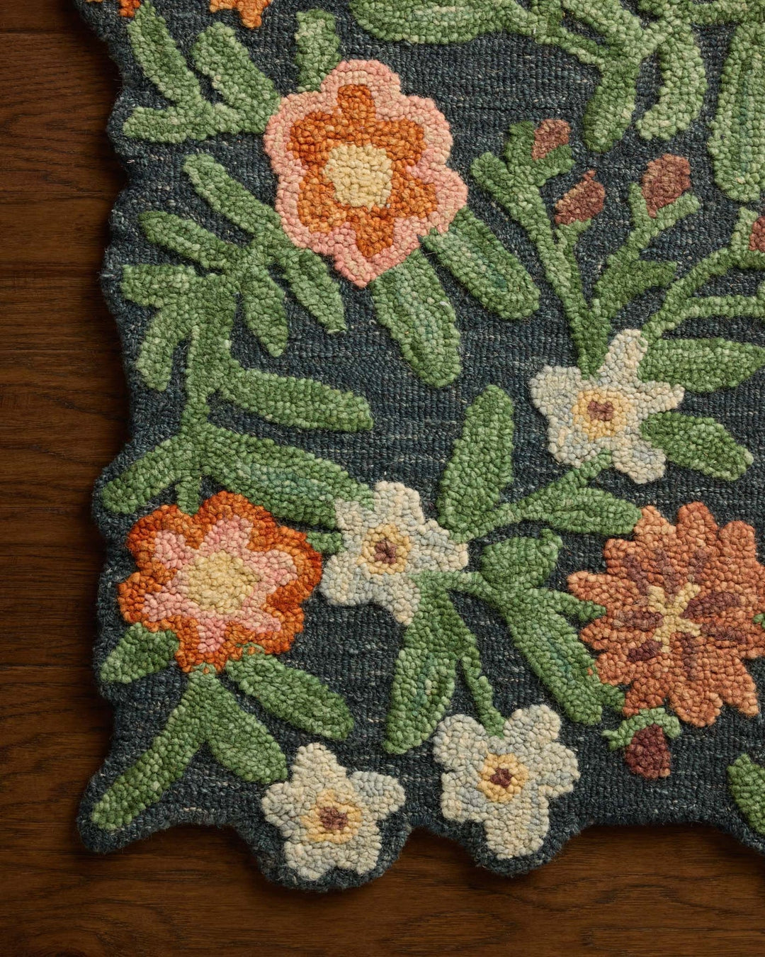 Close-up of the hand-tufted orange and cream blooms on the Edith Navy Multi accent rug - Whats New Furniture Portland OR