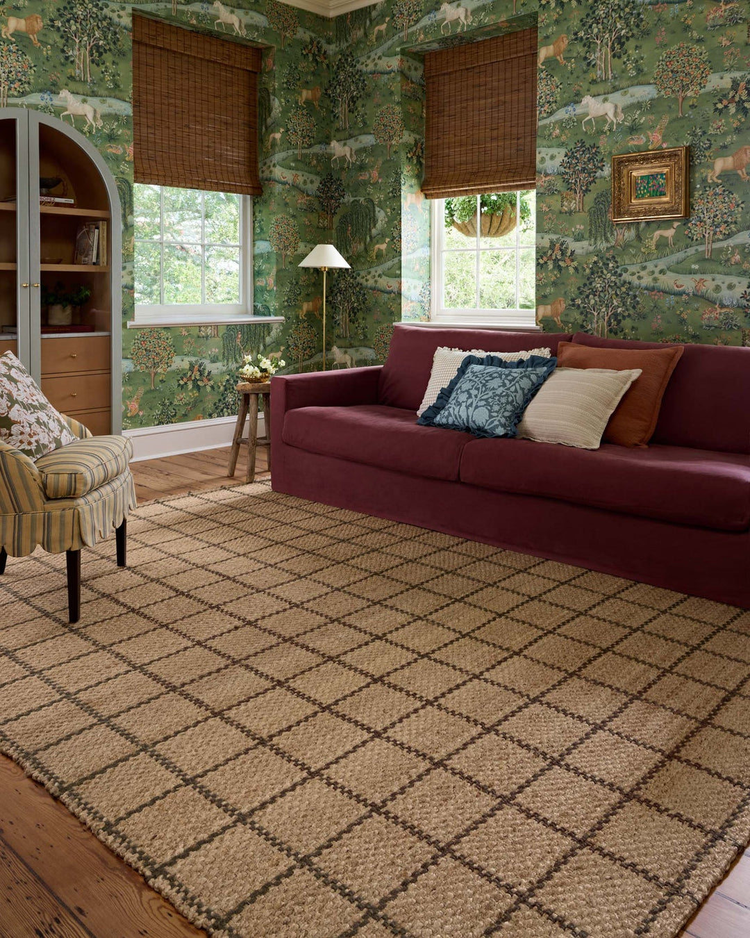 Natural brown Fletcher jute rug styled in a green-walled living room with a burgundy sofa - Whats New Furniture