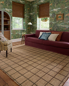 Natural brown Fletcher jute rug styled in a green-walled living room with a burgundy sofa - Whats New Furniture