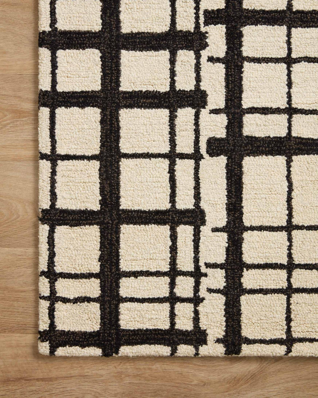 Close-up of the tufted black grid lines on ivory wool showing pile texture on the Polly rug - Whats New Furniture Portland OR