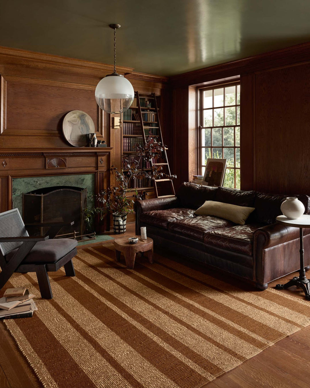 Weatherstaff Cinnamon rug styled in a wood-paneled library living room - Leanne Ford x Loloi - Whats New Furniture Portland OR