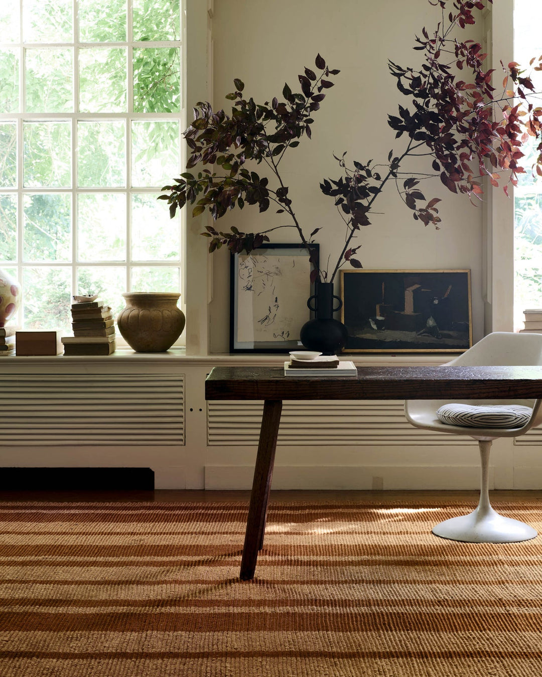Cinnamon Weatherstaff jute rug styled under a writing desk by tall windows in a Portland home - Whats New Furniture