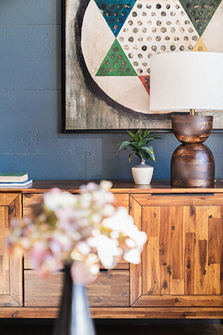 Mid-century modern wood sideboard with geometric artwork and decor at a Portland furniture store.