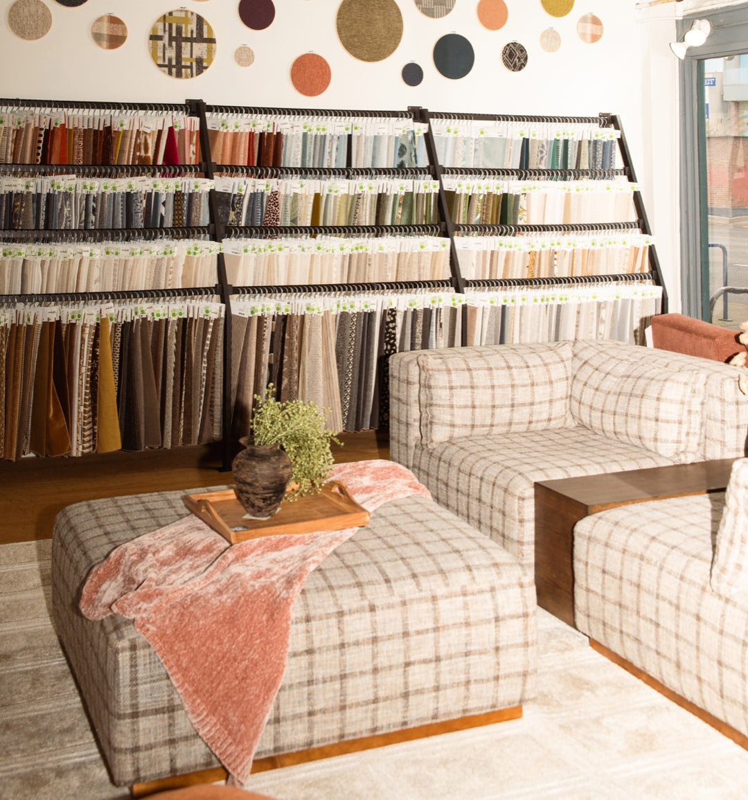 Portland furniture showroom with fabric swatches and custom plaid sofa at Whats New Furniture