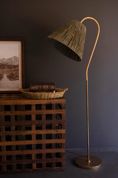 Rattan-Wrapped Arc Floor Lamp with Olive Raffia Shade full height beside a wooden chest - lighting by Kalalou - Whats New Furniture Portland OR