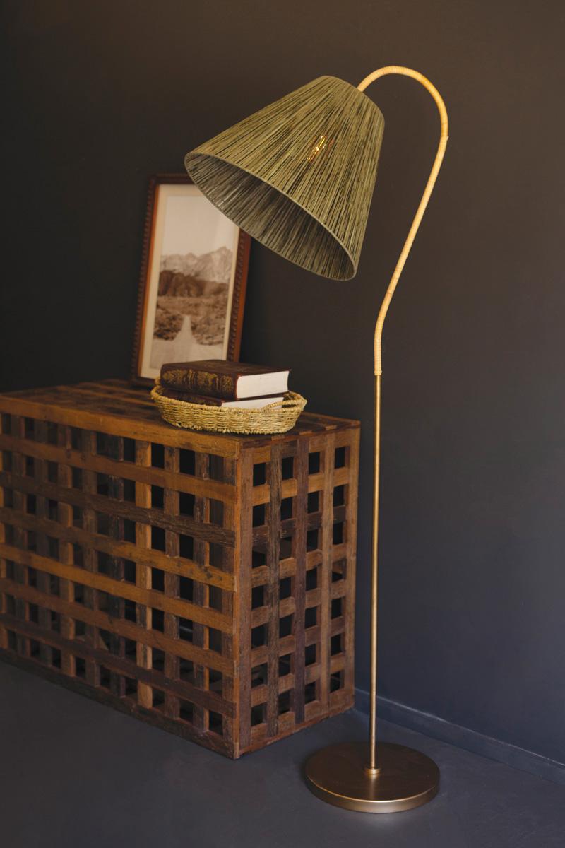 Rattan-Wrapped Arc Floor Lamp with Olive Raffia Shade arcing over a wooden chest in a dark room - lighting by Kalalou - Whats New Furniture Portland OR
