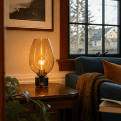 Mikeno amber glass table lamp glowing in a Portland living room - Whats New Furniture