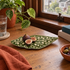 Green stoneware leaf plate styled with fresh figs on a Portland dining table - Whats New Furniture