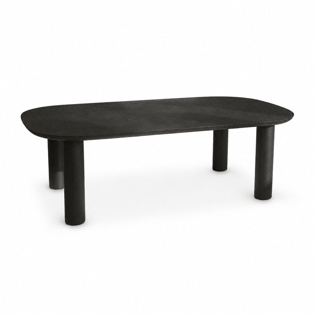 Monsun 47 inch rectangular coffee table in black oak with four cylindrical legs, studio view